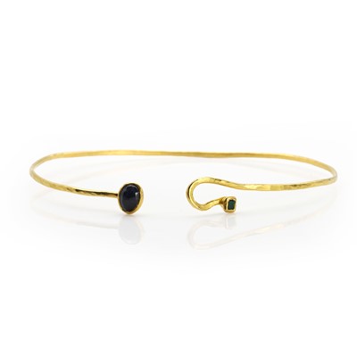 Lot 173 - A sapphire and emerald gold bangle