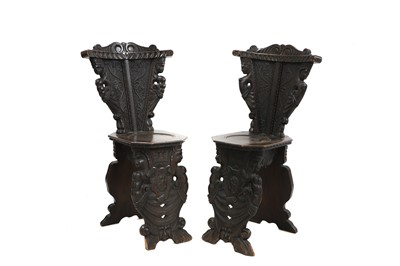 Lot 478 - A mirrored pair of carved walnut sgabello chairs