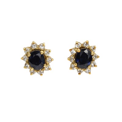 Lot 182 - A pair of gold sapphire and diamond cluster earrings