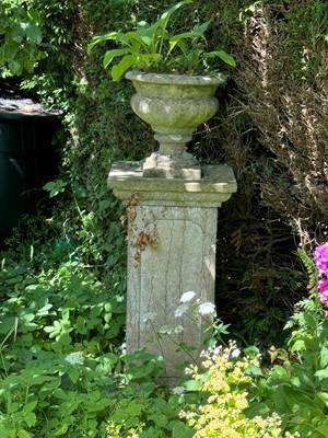 Lot 784 - A reconstituted stone urn on a plinth