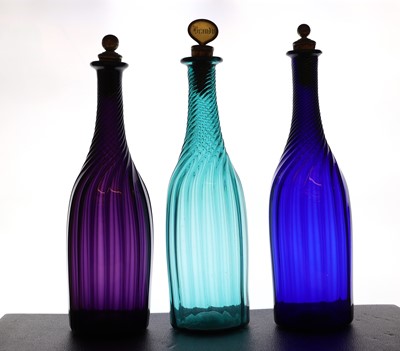 Lot 289 - Three coloured glass spiral moulded bottle decanters