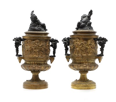 Lot 653 - A pair of gilt and patinated metal urns and covers