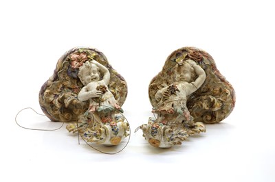Lot 219 - A pair of faience Rococo cherub wall brackets