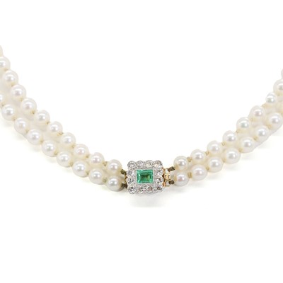 Lot 231 - A graduated two row cultured pearl necklace with an emerald and diamond clasp