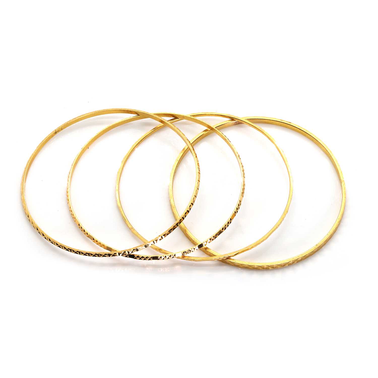 Lot 1351 - A group of four high carat yellow gold bangles