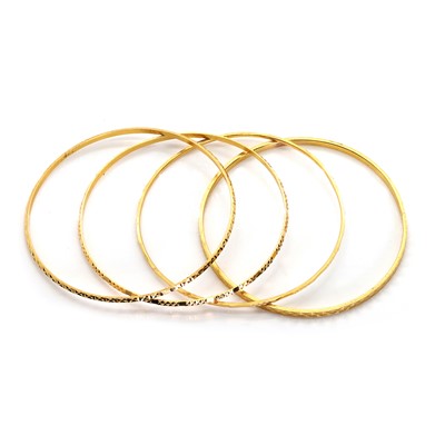 Lot 1351 - A group of four high carat yellow gold bangles