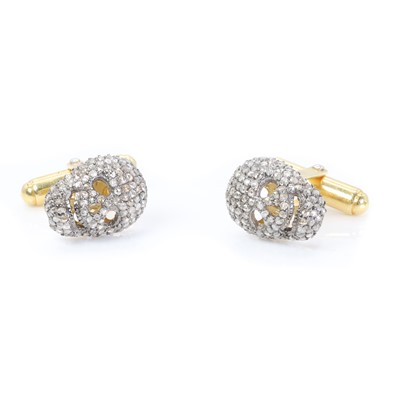 Lot 1428 - A pair of diamond set novelty skull cufflinks