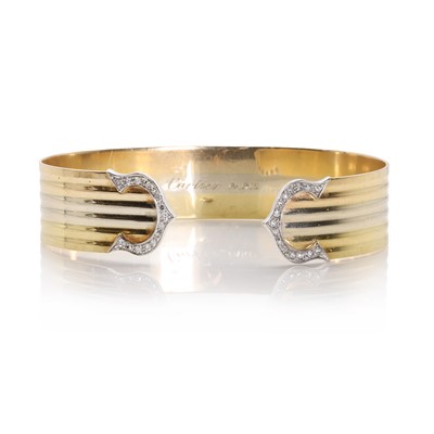 Lot 1145 - A three colour gold diamond torque bangle