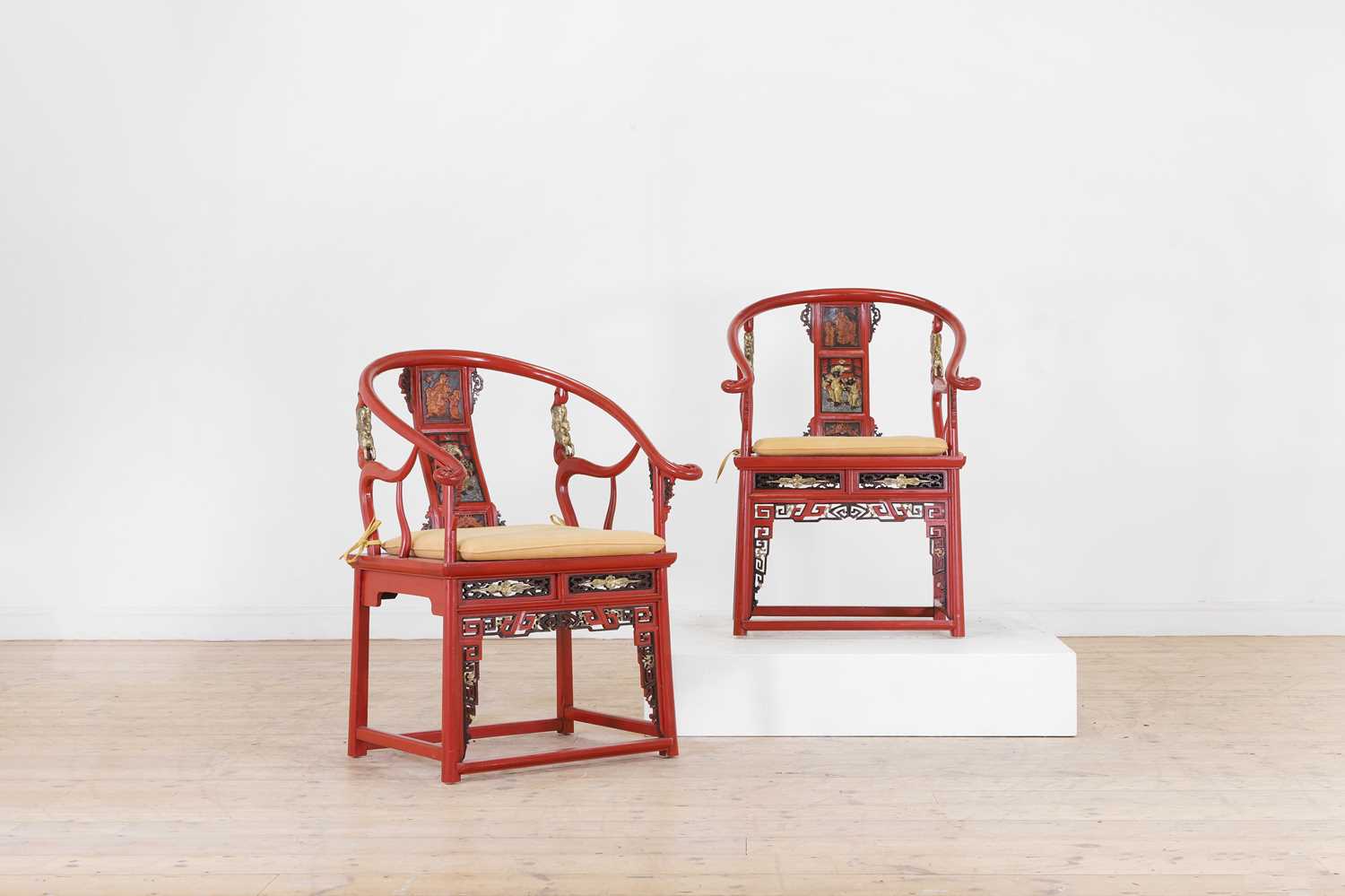 Lot 636 - A pair of red lacquer horseshoe-back chairs