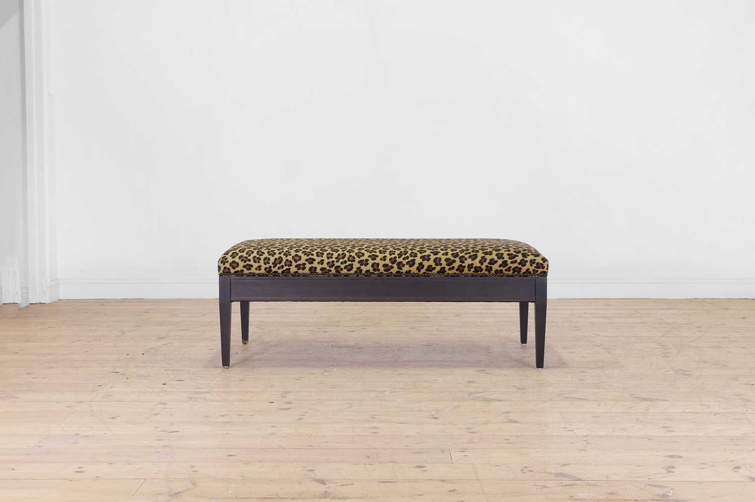 Lot 633 - An imitation leopard-skin and ebonised wooden ottoman