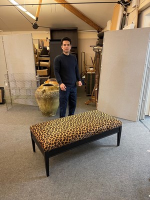Lot 633 - An imitation leopard-skin and ebonised wooden ottoman