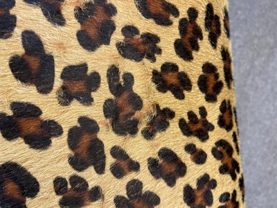 Lot 633 - An imitation leopard-skin and ebonised wooden ottoman