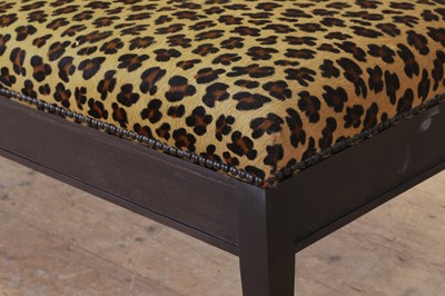 Lot 633 - An imitation leopard-skin and ebonised wooden ottoman