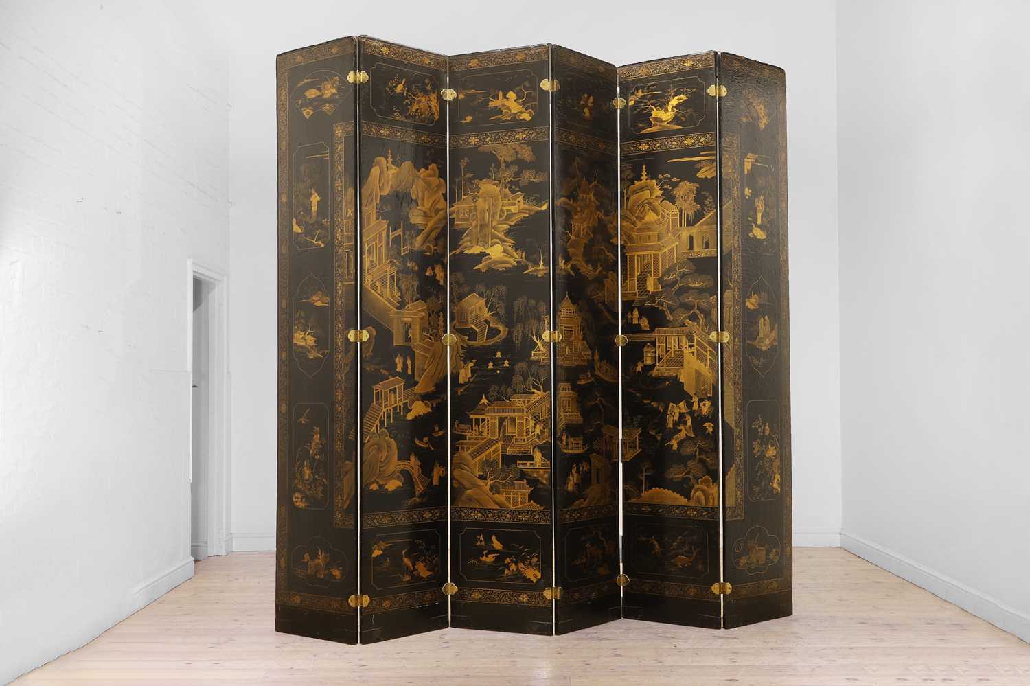 Lot 643 - A black and gilt lacquer folding screen