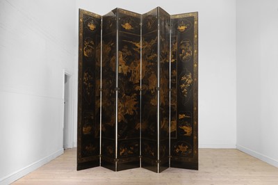 Lot 643 - A black and gilt lacquer folding screen