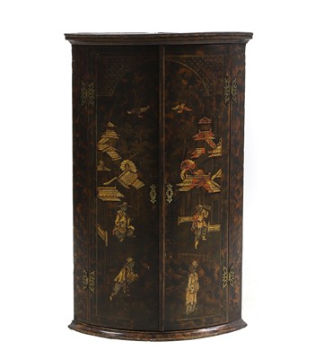 Lot 744 - A Georgian japanned bow front hanging corner cupboard