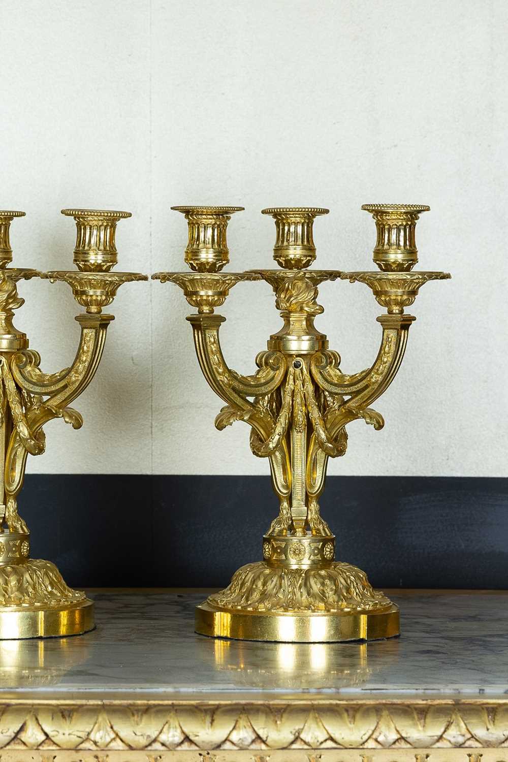 Lot A pair of Louis XVI ormolu candelabra in the manner of Delafosse of Paris