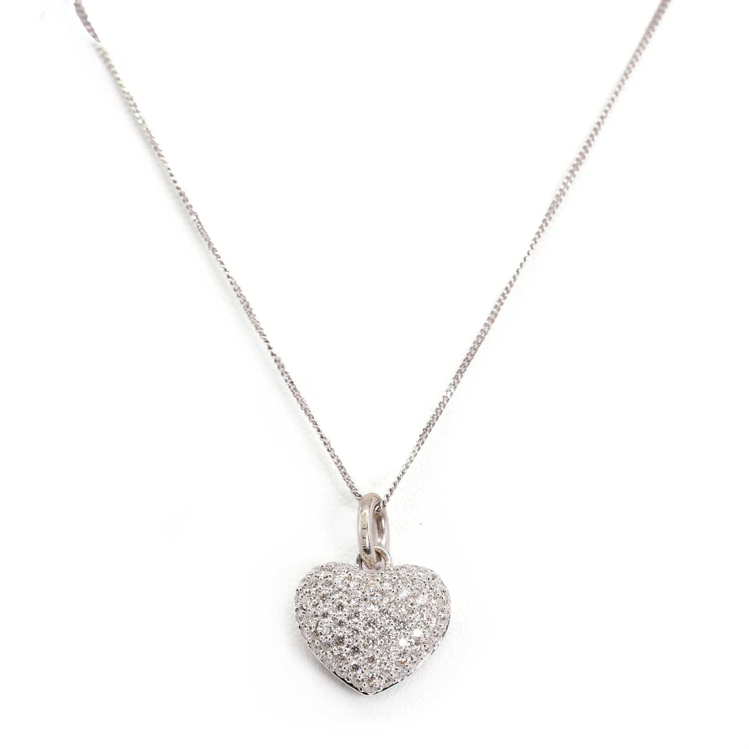 Lot 1115 - An 18ct white gold heart shaped diamond pendant and chain