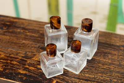 Lot 133 - A set of four cut-glass perfume bottles by Louis Vuitton