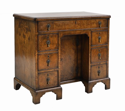 Lot 705 - A George I crossbanded walnut kneehole desk