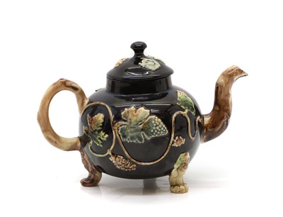 Lot 169 - A Staffordshire black glazed teapot of Whieldon type