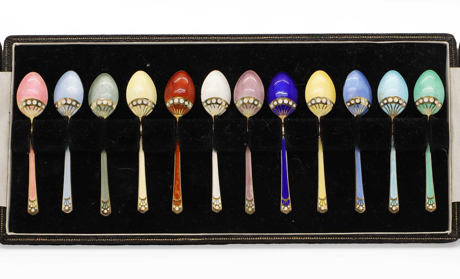 Lot 11 - A set of twelve silver gilt and enamel coffee spoons