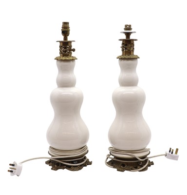 Lot 659 - A pair of earthenware and brass mounted table lamps