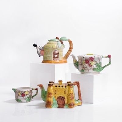 Lot 196 - A group of three pottery teapots and a milk jug