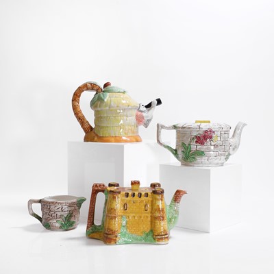 Lot 196 - A group of three pottery teapots and a milk jug