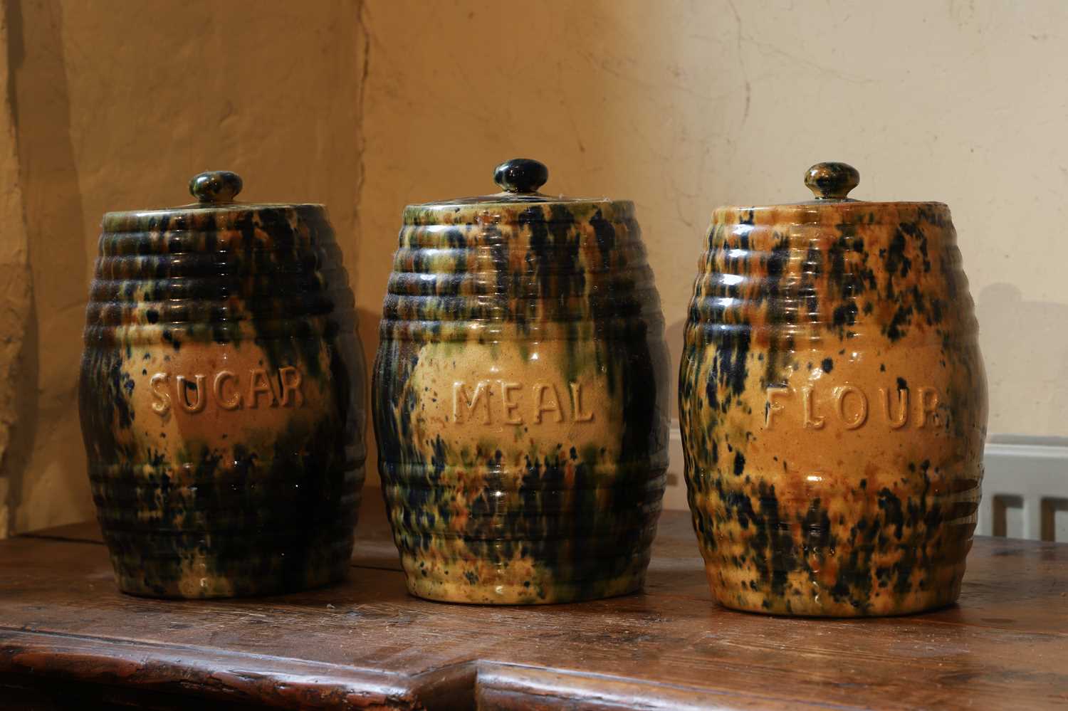 Lot 516 - A set of three glazed earthenware storage jars and covers