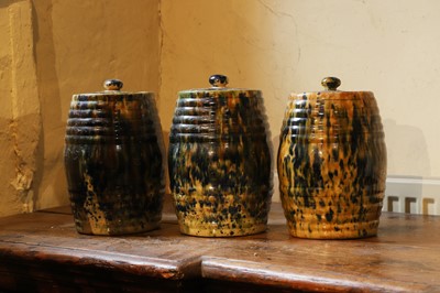 Lot 516 - A set of three glazed earthenware storage jars and covers