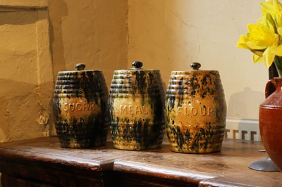 Lot 516 - A set of three glazed earthenware storage jars and covers