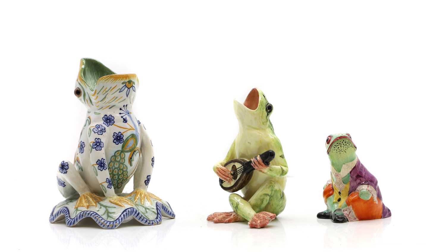 Lot 320 - Three pottery figures of frogs