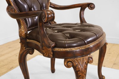 Lot 9 - A pair of buttoned leather and parcel-gilt wooden armchairs
