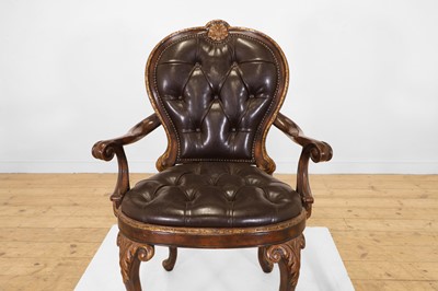 Lot 9 - A pair of buttoned leather and parcel-gilt wooden armchairs
