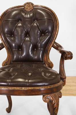 Lot 9 - A pair of buttoned leather and parcel-gilt wooden armchairs