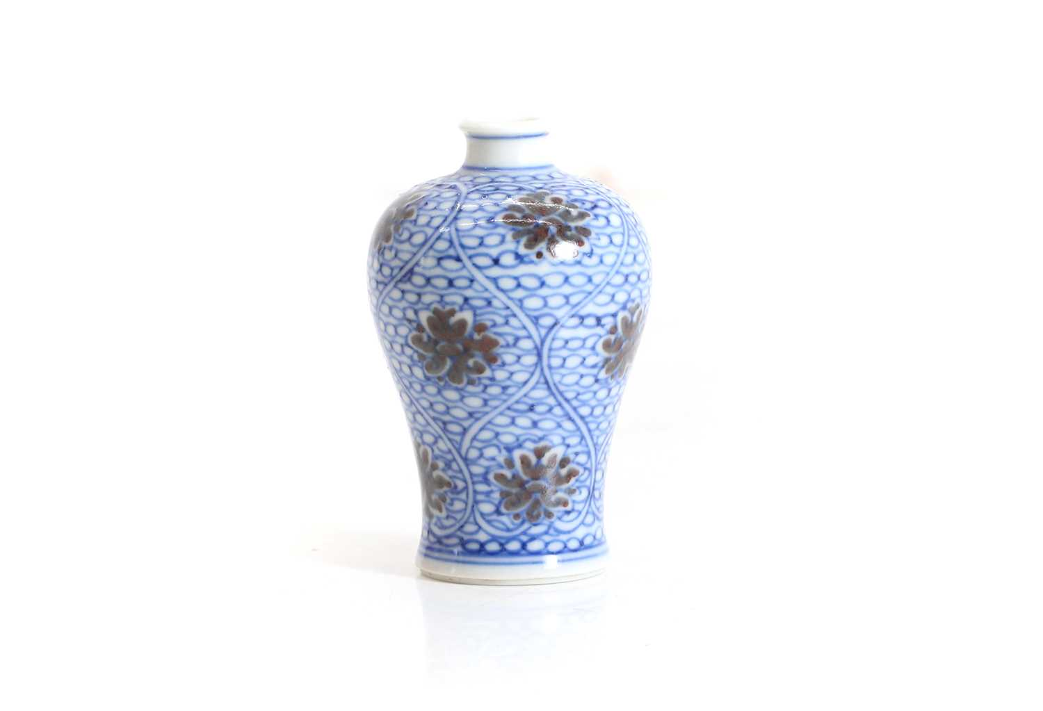 Lot 102 - A Chinese copper red and underglaze blue miniature vase
