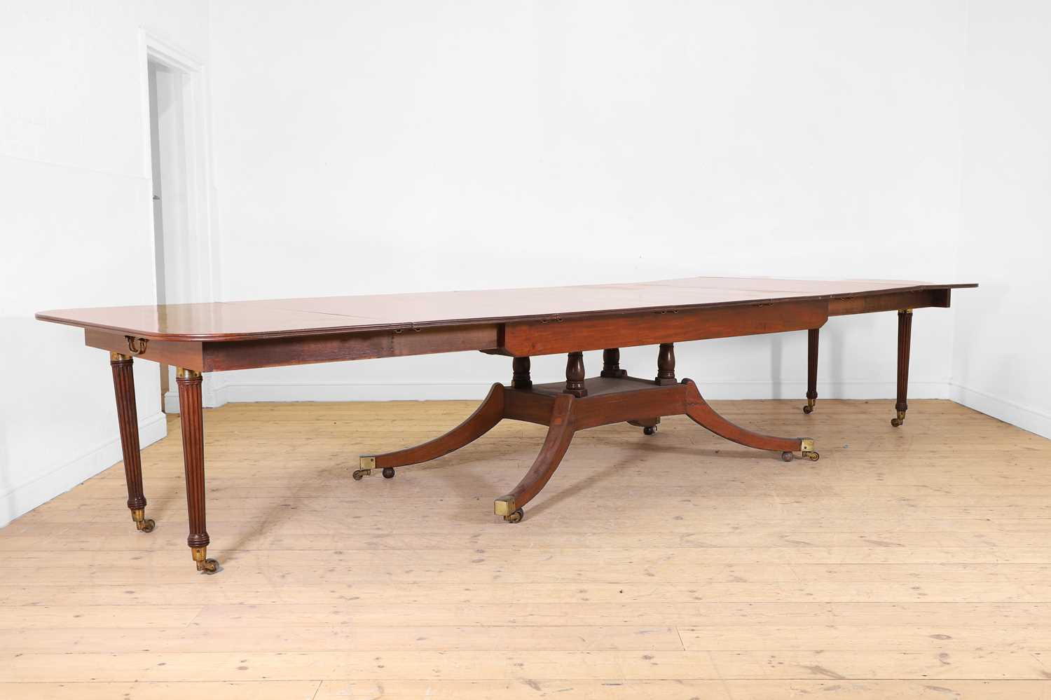 Lot 571 - A large George III figured mahogany extending dining table in the manner of Gillows