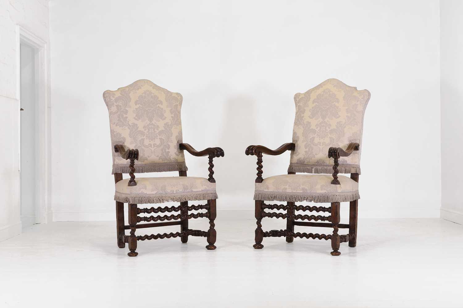 Lot 27 - A pair of large carved-walnut open armchairs