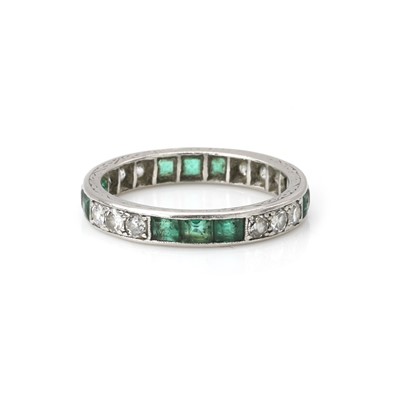Lot 69 - A platinum emerald and diamond eternity ring