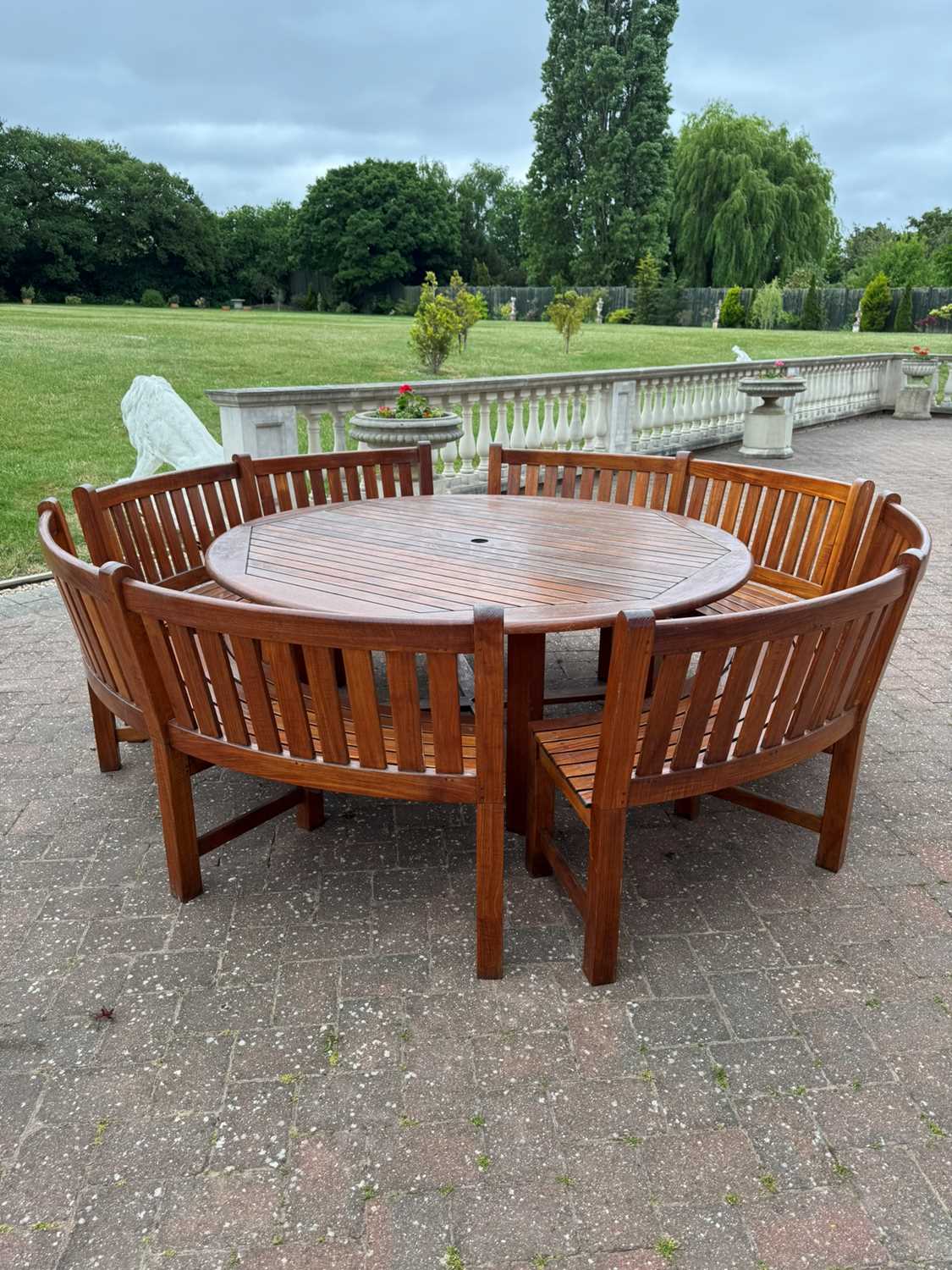 Lot 600 - A Westminster teak garden suite of four benches and a circular table