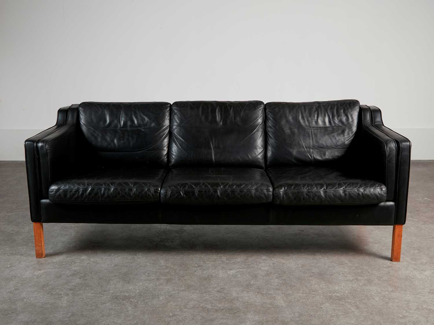Lot 88 - A black leather three-seater settee