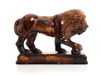 Lot 232 - A treacle glazed pottery lion