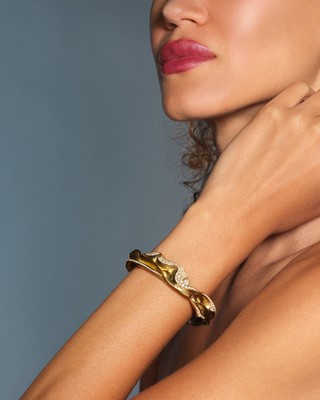 Lot 260 - Ken Bolan and Marinette Domon: a gold diamond 'Touche de Soie' bangle