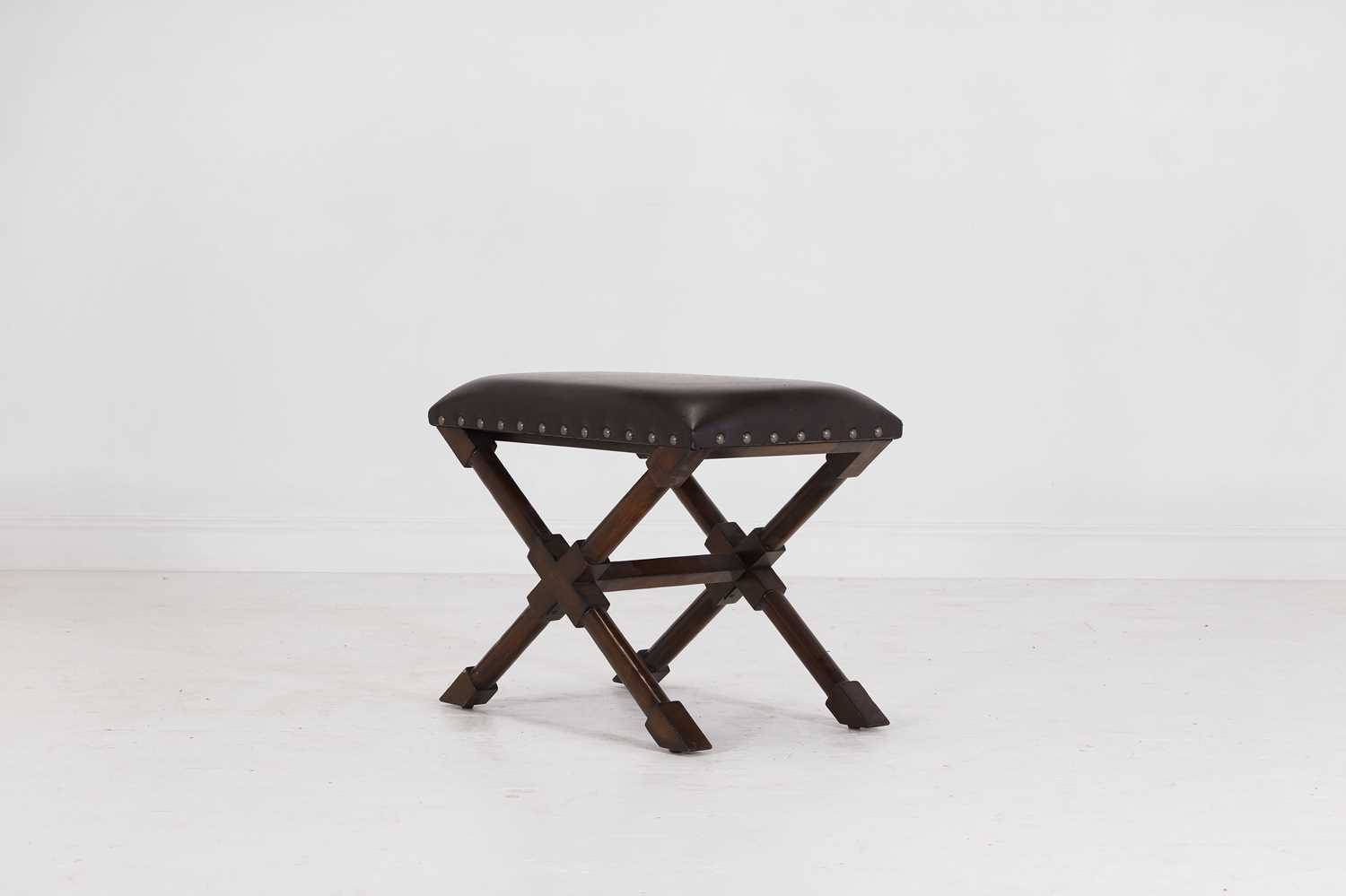 Lot 536 - A leather and stained wooden 'X' frame stool