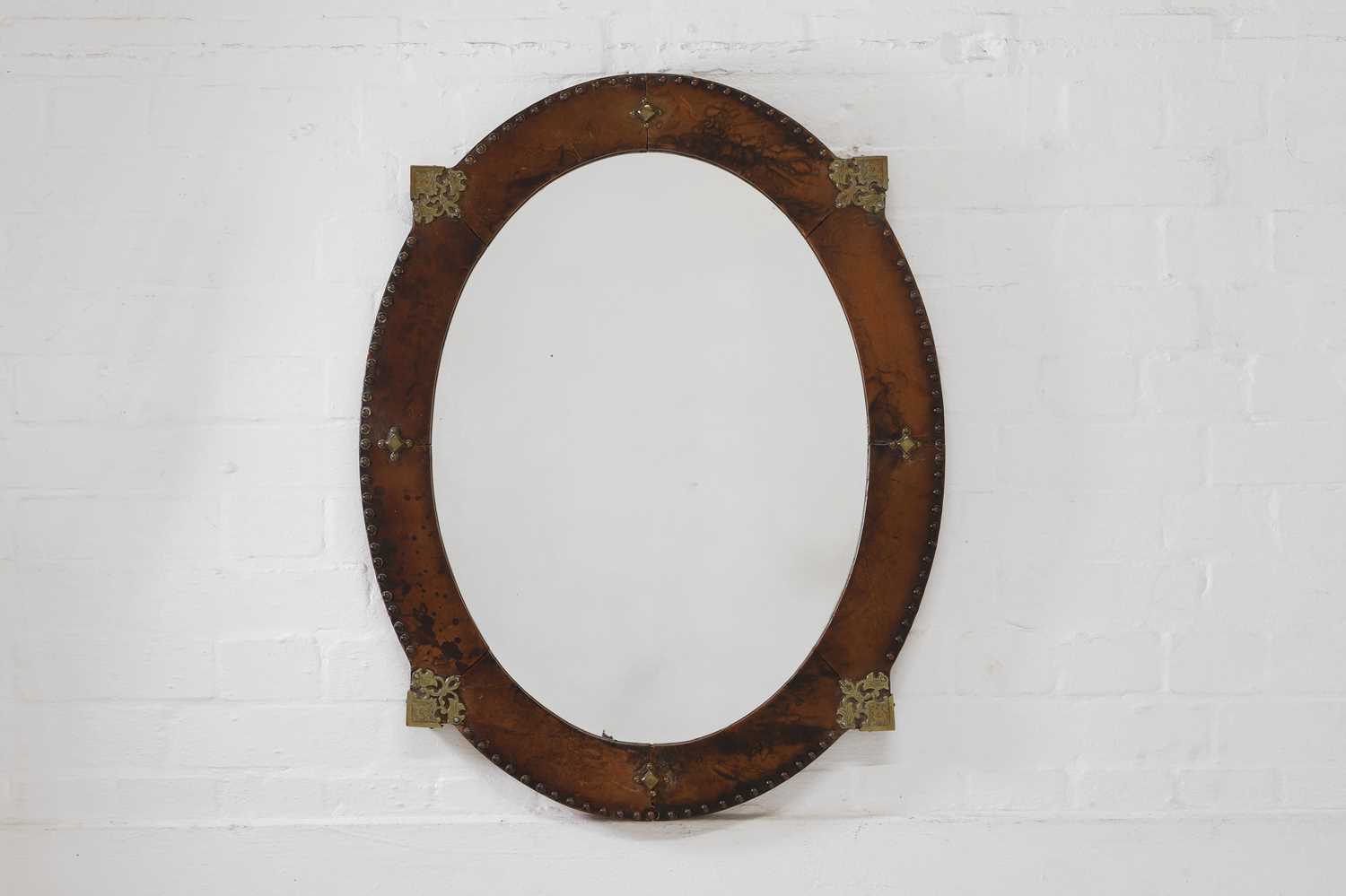 Lot 339 - A leather and brass oval mirror