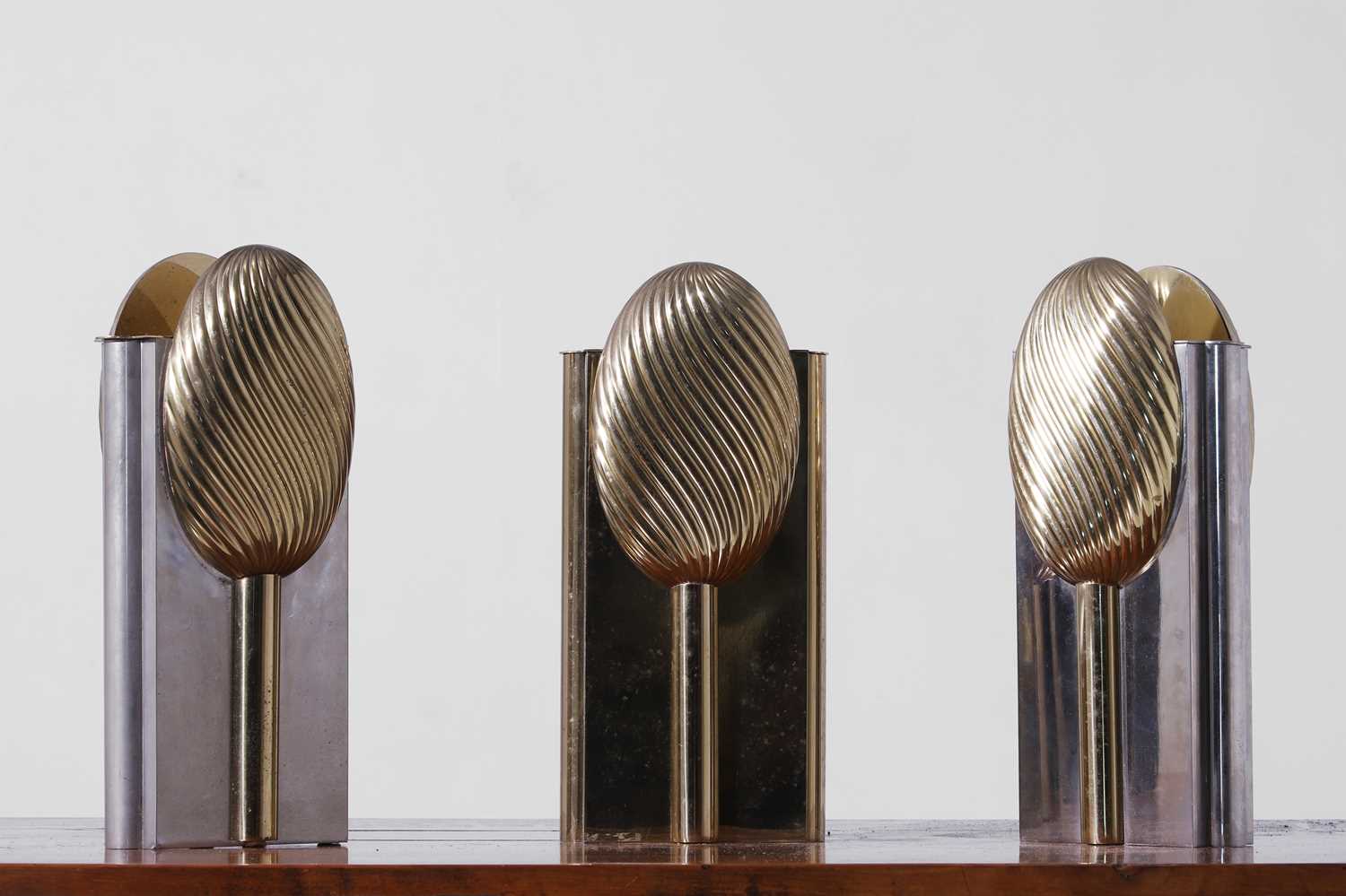 Lot 558 - A set of three nickel and brass vases