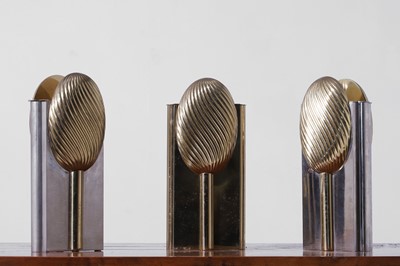 Lot 558 - A set of three nickel and brass vases