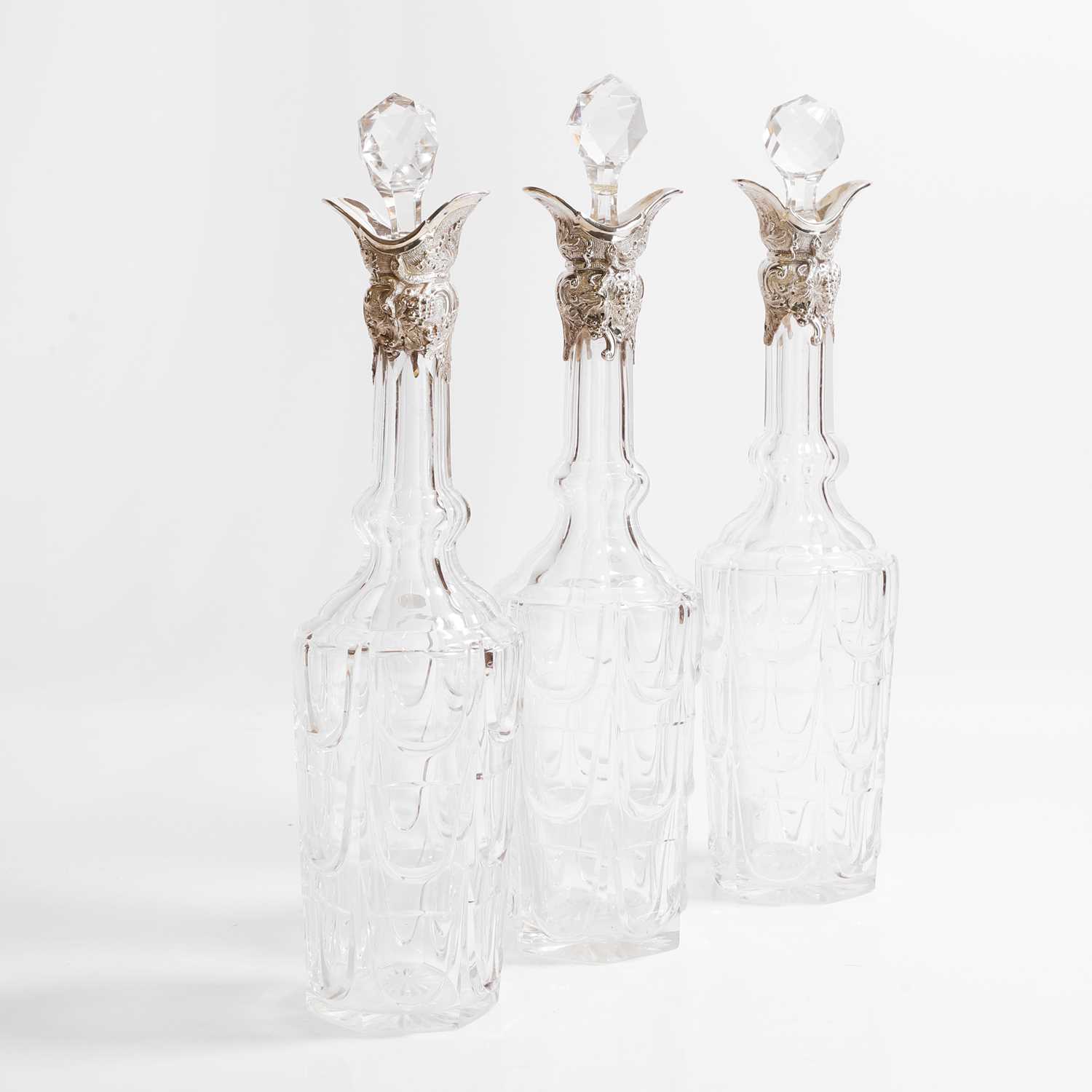 Lot 49 - A set of three silver-mounted cut-glass decanters