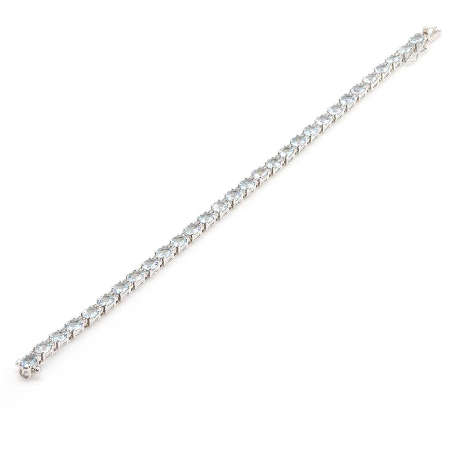 Lot 79 - An 18ct white gold aquamarine and diamond line bracelet